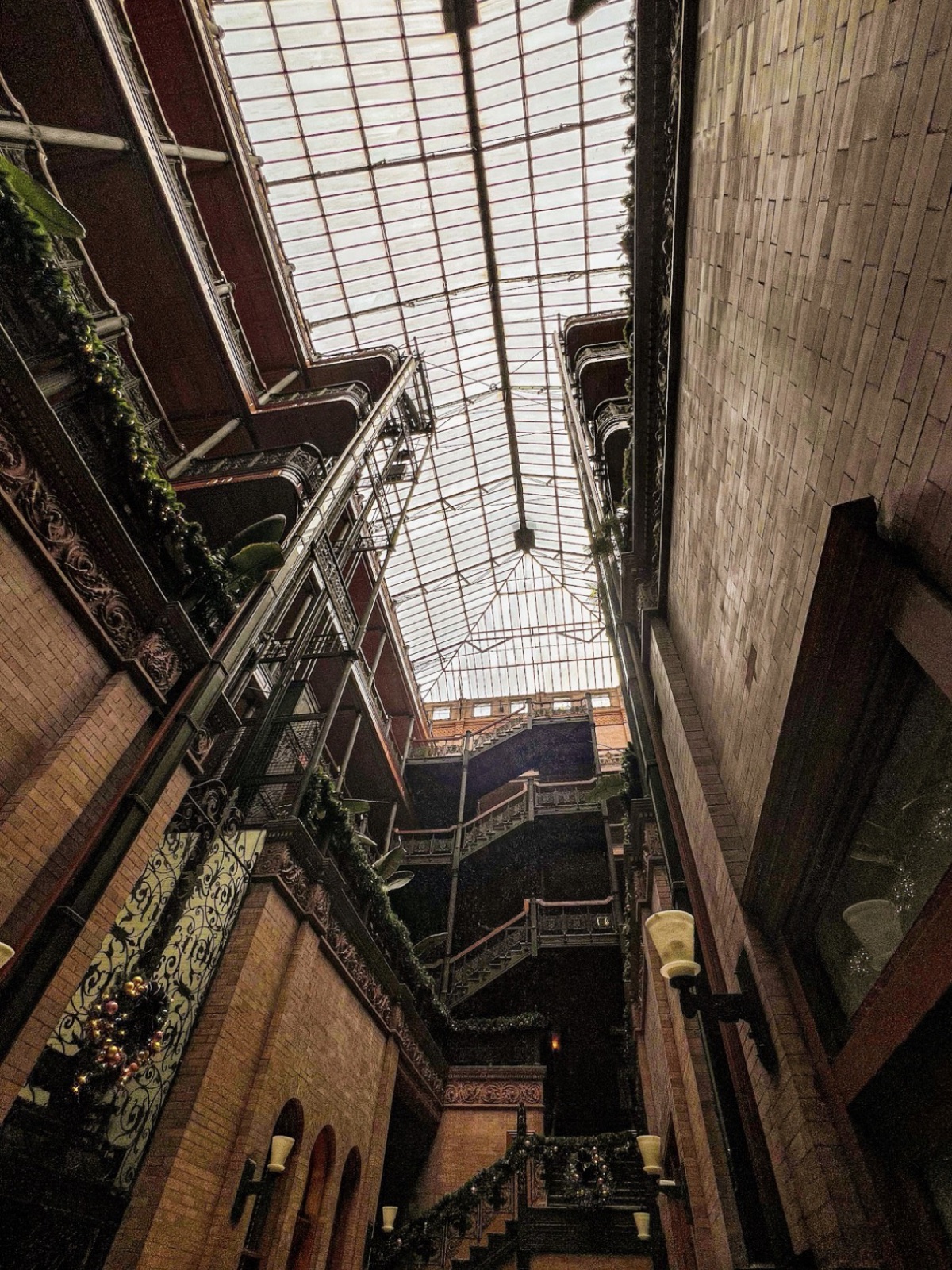 Looking up through the ironwork balconies and glass roof of a historic atrium